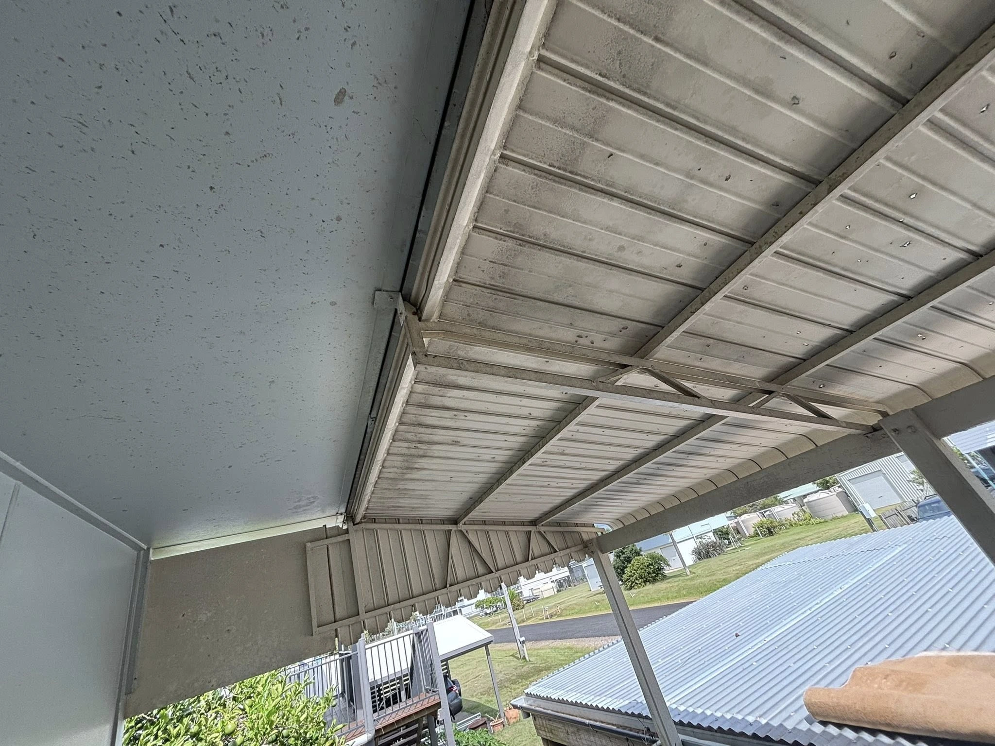 Patio ceiling before cleaning — covered in grime and mould